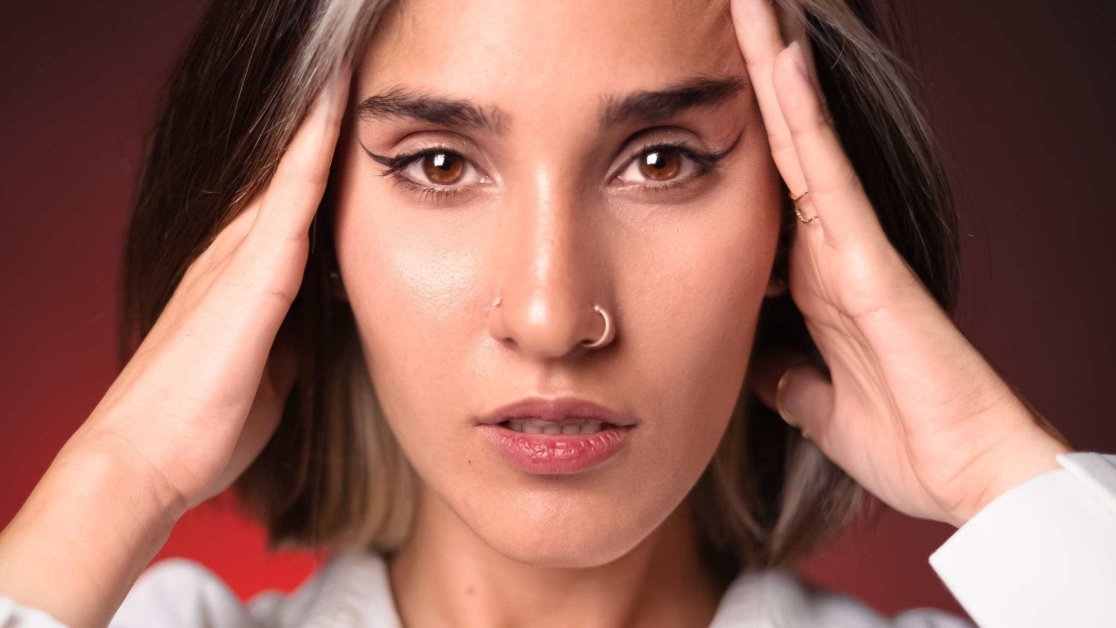 femme avec mal de tête à cause d'un piercing